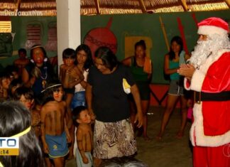 Crianças indígenas cantam ao receberem presentes e visita do Papai Noel pela 1ª vez em aldeia